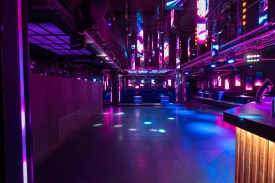 Salle de toilettes modernes avec lavabos en acier inoxydable, miroirs, cabines fermées et éclairage au plafond.