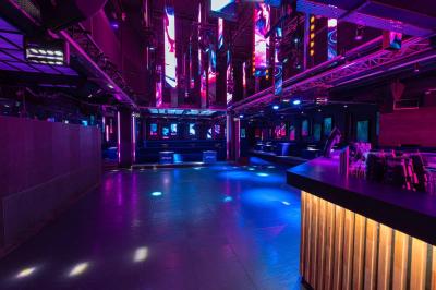 Salle de toilettes modernes avec lavabos en acier inoxydable, miroirs, cabines fermées et éclairage au plafond.