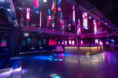 Salle de toilettes modernes avec lavabos en acier inoxydable, miroirs, cabines fermées et éclairage au plafond.