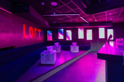 Salle de toilettes modernes avec lavabos en acier inoxydable, miroirs, cabines fermées et éclairage au plafond.