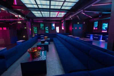 Salle de toilettes modernes avec lavabos en acier inoxydable, miroirs, cabines fermées et éclairage au plafond.