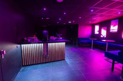 Salle de toilettes modernes avec lavabos en acier inoxydable, miroirs, cabines fermées et éclairage au plafond.