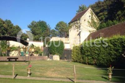 Cibles de tir à l'arc alignées sur un terrain herbeux, entourées d'arbres, avec deux personnes à proximité.