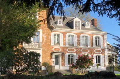 Maison en briques et crépi avec jardin, panneau de bienvenue pour un mariage au premier plan.