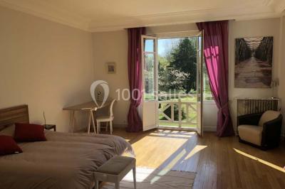 Maison en briques et crépi avec jardin, panneau de bienvenue pour un mariage au premier plan.