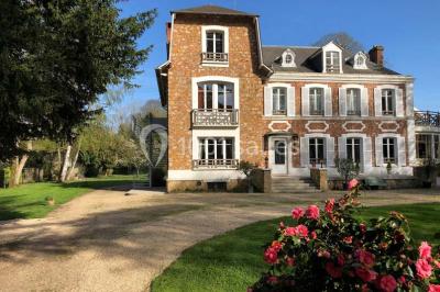 Maison en briques et crépi avec jardin, panneau de bienvenue pour un mariage au premier plan.