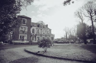 Maison en briques et crépi avec jardin, panneau de bienvenue pour un mariage au premier plan.