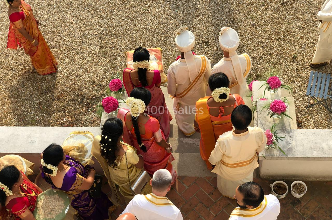 Vue aérienne d'un groupe de personnes en tenues traditionnelles lors d'une cérémonie en extérieur.