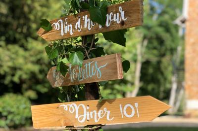 Maison en briques et crépi avec jardin, panneau de bienvenue pour un mariage au premier plan.