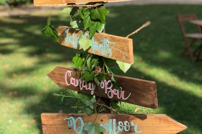 Maison en briques et crépi avec jardin, panneau de bienvenue pour un mariage au premier plan.