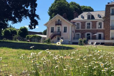 Maison en briques et crépi avec jardin, panneau de bienvenue pour un mariage au premier plan.