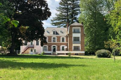 Maison en briques et crépi avec jardin, panneau de bienvenue pour un mariage au premier plan.
