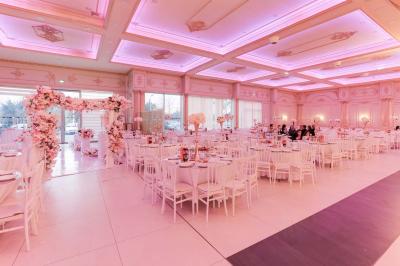 Bâtiment moderne avec façade grise, enseigne ’Bérénice Salle de Réception’, parking avec quelques véhicules.