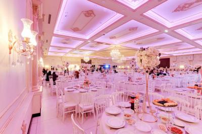 Bâtiment moderne avec façade grise, enseigne ’Bérénice Salle de Réception’, parking avec quelques véhicules.