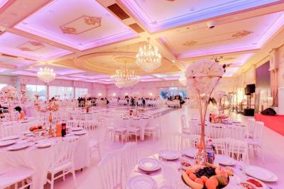 Bâtiment moderne avec façade grise, enseigne ’Bérénice Salle de Réception’, parking avec quelques véhicules.