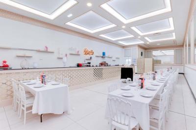 Bâtiment moderne avec façade grise, enseigne ’Bérénice Salle de Réception’, parking avec quelques véhicules.