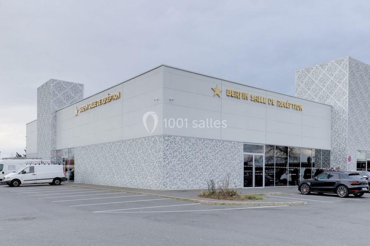 Bâtiment moderne avec façade grise, enseigne ’Bérénice Salle de Réception’, parking avec quelques véhicules.