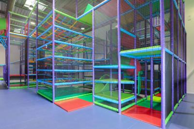 Bâtiment moderne avec façade grise, enseigne ’Bérénice Salle de Réception’, parking avec quelques véhicules.