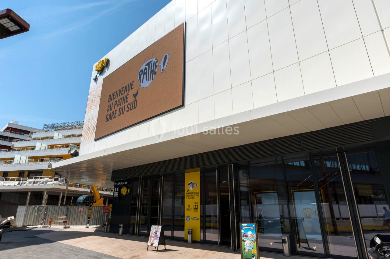 Façade d'un cinéma Pathé avec une entrée vitrée et un écran affichant un message de bienvenue.