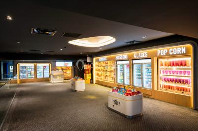 Terrasse d'un café Starbucks devant un immeuble moderne aux façades blanches et jaunes, sous un ciel partiellement nuageux.