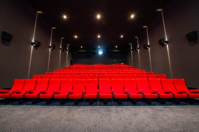 Terrasse d'un café Starbucks devant un immeuble moderne aux façades blanches et jaunes, sous un ciel partiellement nuageux.