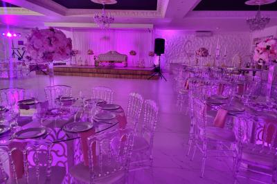 Façade éclairée d'un bâtiment avec l'enseigne lumineuse ’Le Strass réception’ visible de nuit.