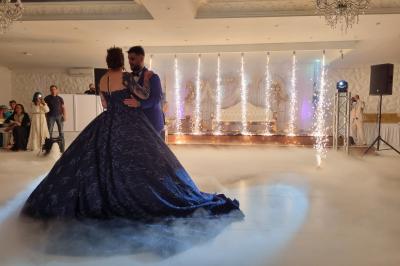 Façade éclairée d'un bâtiment avec l'enseigne lumineuse ’Le Strass réception’ visible de nuit.