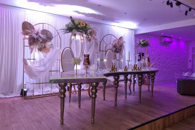 Façade éclairée d'un bâtiment avec l'enseigne lumineuse ’Le Strass réception’ visible de nuit.