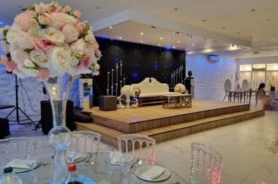 Façade éclairée d'un bâtiment avec l'enseigne lumineuse ’Le Strass réception’ visible de nuit.