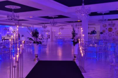 Façade éclairée d'un bâtiment avec l'enseigne lumineuse ’Le Strass réception’ visible de nuit.