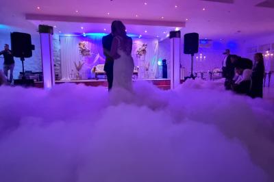 Façade éclairée d'un bâtiment avec l'enseigne lumineuse ’Le Strass réception’ visible de nuit.