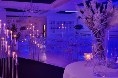 Façade éclairée d'un bâtiment avec l'enseigne lumineuse ’Le Strass réception’ visible de nuit.