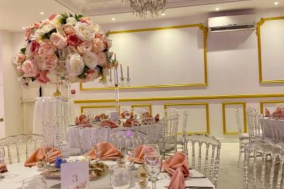 Façade éclairée d'un bâtiment avec l'enseigne lumineuse ’Le Strass réception’ visible de nuit.