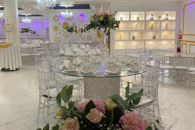 Façade éclairée d'un bâtiment avec l'enseigne lumineuse ’Le Strass réception’ visible de nuit.