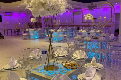 Façade éclairée d'un bâtiment avec l'enseigne lumineuse ’Le Strass réception’ visible de nuit.