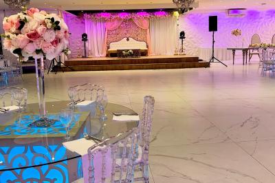 Façade éclairée d'un bâtiment avec l'enseigne lumineuse ’Le Strass réception’ visible de nuit.