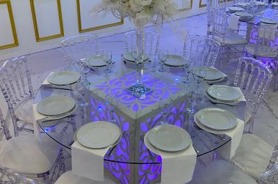 Façade éclairée d'un bâtiment avec l'enseigne lumineuse ’Le Strass réception’ visible de nuit.