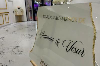 Façade éclairée d'un bâtiment avec l'enseigne lumineuse ’Le Strass réception’ visible de nuit.