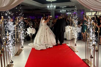 Façade éclairée d'un bâtiment avec l'enseigne lumineuse ’Le Strass réception’ visible de nuit.