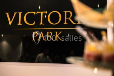 Illustration en noir et blanc de grilles ouvertes devant des arbres, avec le texte ’Victoria Park, l'événementiel autrement’.