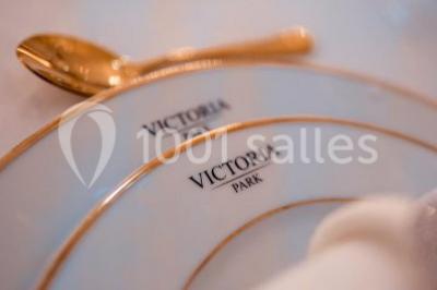 Illustration en noir et blanc de grilles ouvertes devant des arbres, avec le texte ’Victoria Park, l'événementiel autrement’.