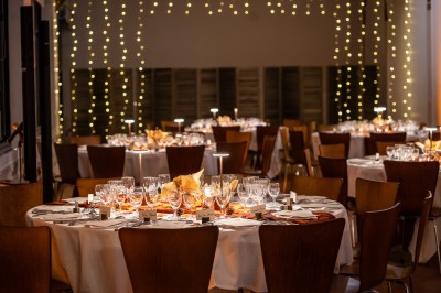 Feu d'artifice illuminant le ciel nocturne au-dessus d'un espace extérieur avec arbres et structure éclairée.