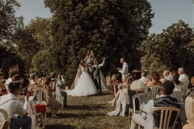Feu d'artifice illuminant le ciel nocturne au-dessus d'un espace extérieur avec arbres et structure éclairée.