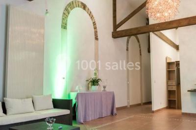 Bâtiment éclairé avec des fenêtres rouges, arbres décorés de lumières blanches et allée pavée de nuit.