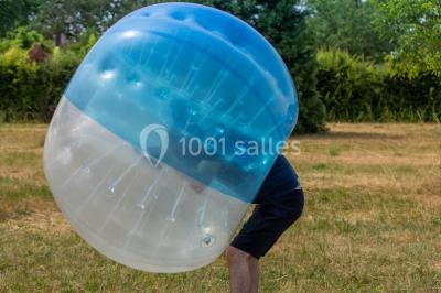 Bâtiment éclairé avec des fenêtres rouges, arbres décorés de lumières blanches et allée pavée de nuit.