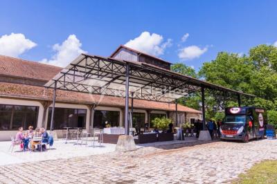 Bâtiment éclairé avec des fenêtres rouges, arbres décorés de lumières blanches et allée pavée de nuit.