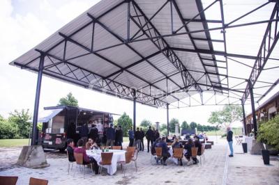 Bâtiment éclairé avec des fenêtres rouges, arbres décorés de lumières blanches et allée pavée de nuit.