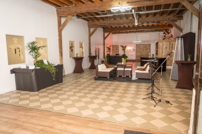 Salle de réunion avec une grande table rectangulaire, chaises noires, documents, bouteilles d'eau et écran de présentation.