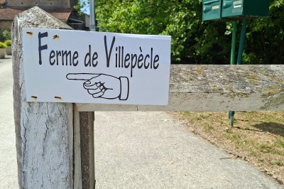 Salle de réunion avec une grande table rectangulaire, chaises noires, documents, bouteilles d'eau et écran de présentation.