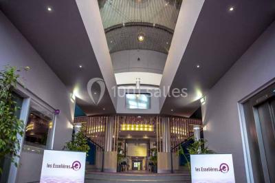 Miniature Location salle Villejuif (Val-de-Marne) - Espace Evénementiel Les Esselières - Paris Sud #2 Entrée d'un bâtiment avec escalier central, écrans d'affichage, plantes décoratives et sol en parquet.